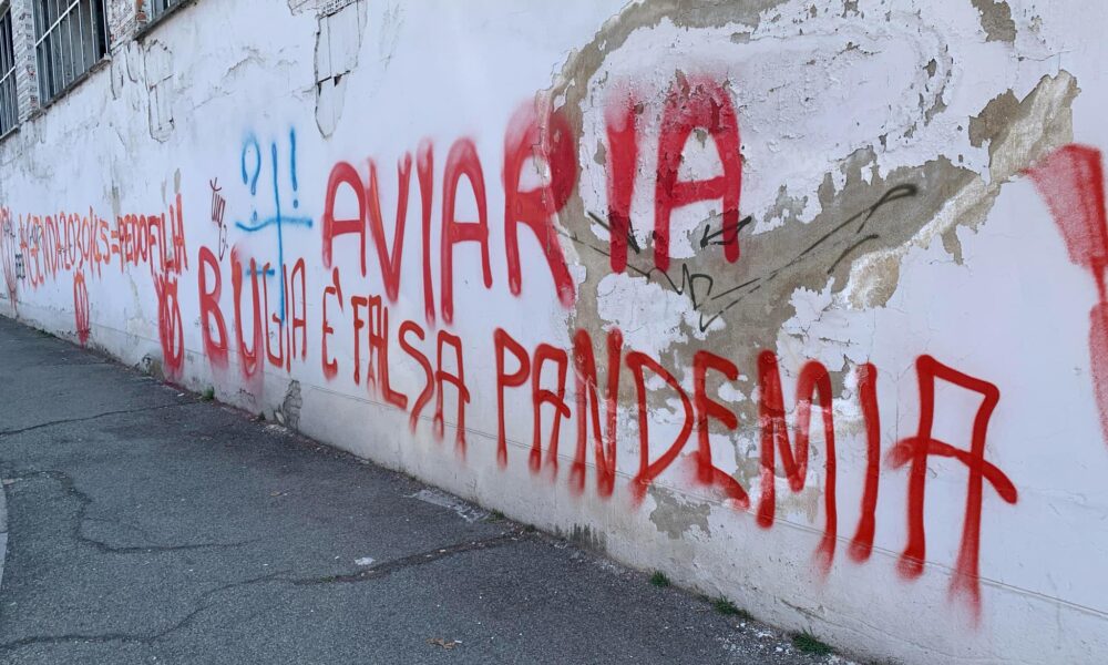 Il muro dell'ex lanificio di via Carso devastato dai vandali. Scritte di vernice rossa, a caratteri cubitali, vergate da un movimento legato alla galassia “No vax”.